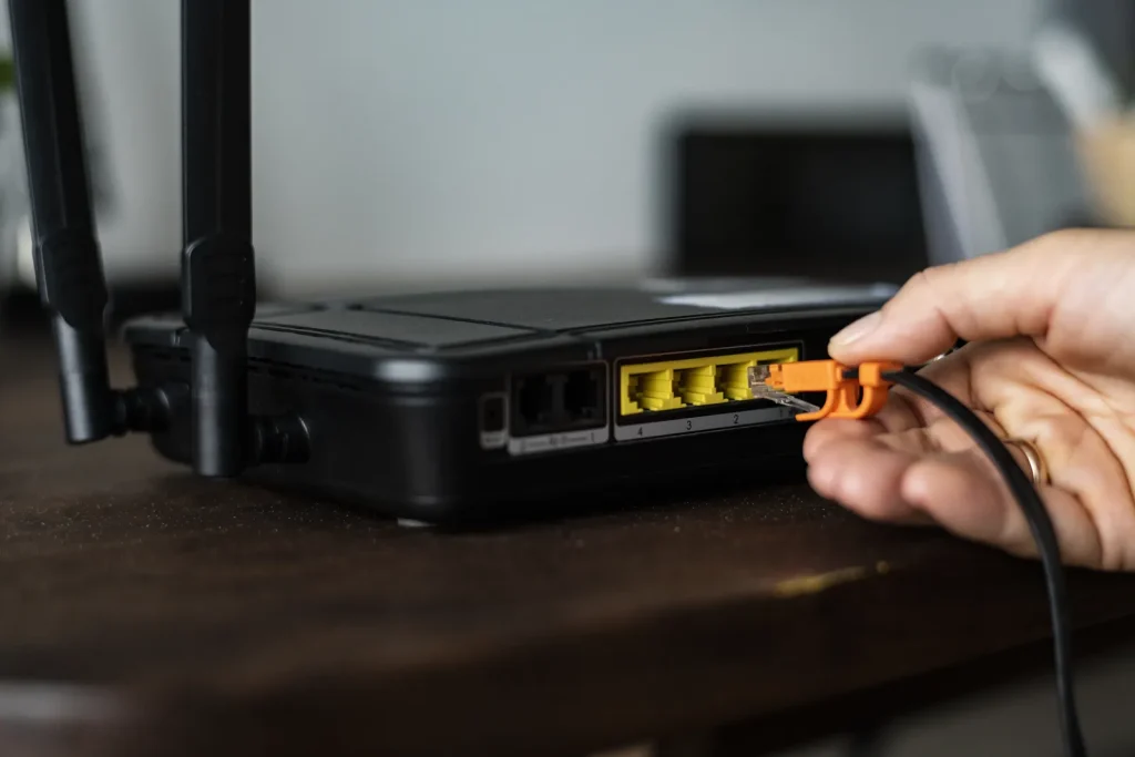 Mano che inserisce un cavo di rete nella porta di un router